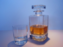A decanter of bourbon whiskey and a glass.