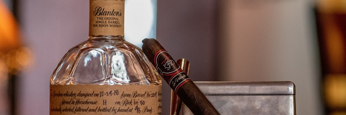 Blanton's Bourbon Bottle and a Cigar on a bar top